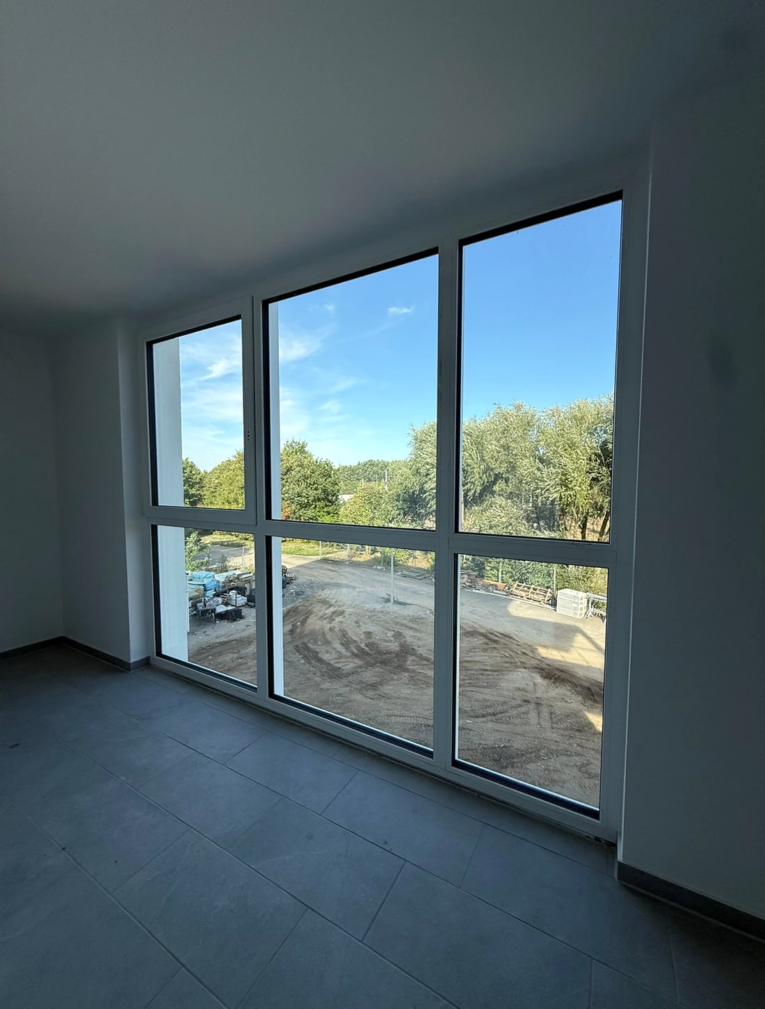 Großzügige Fensterfront in einem hellen Wohnraum