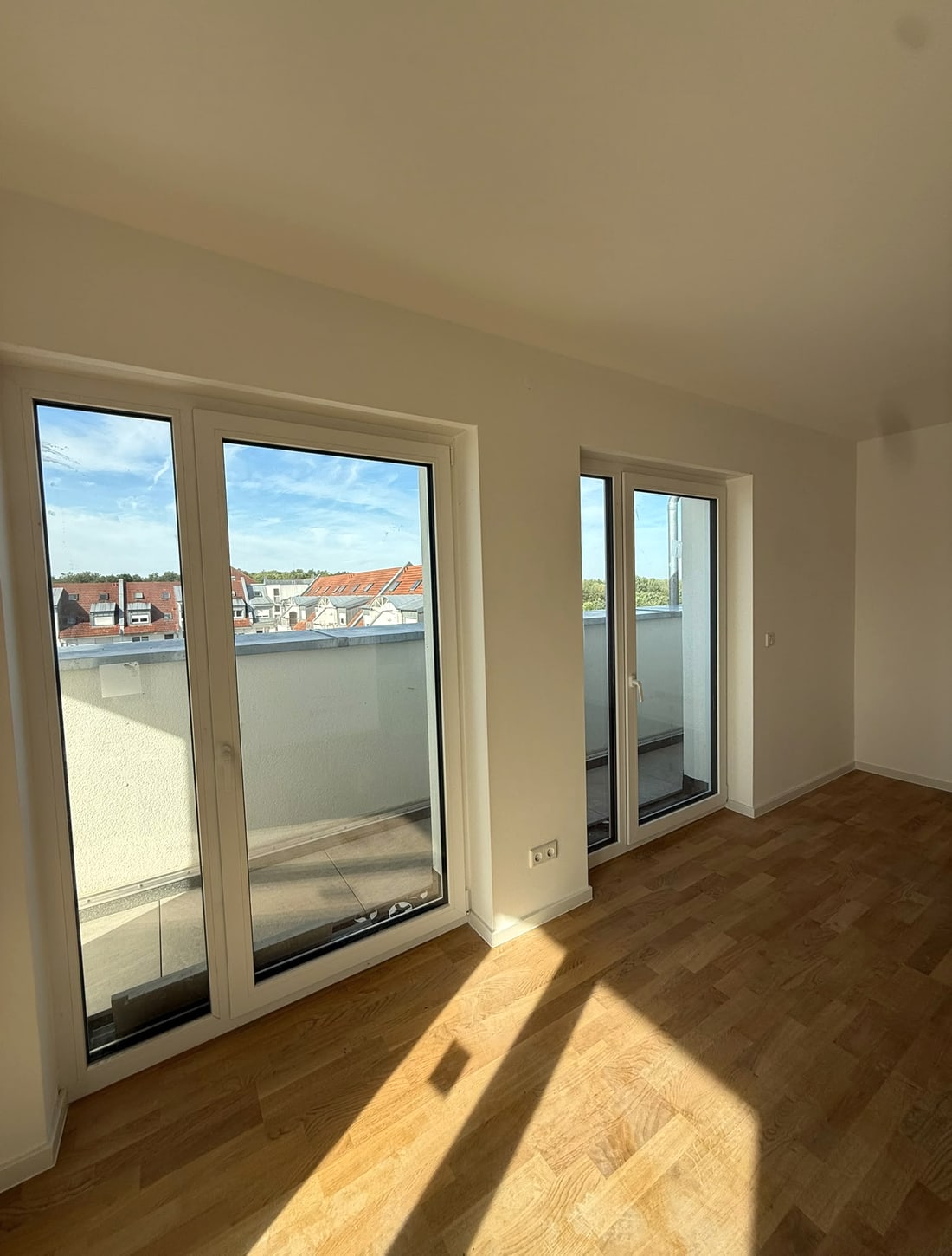 Heller Wohnraum mit zwei bodentiefen Fenstertüren